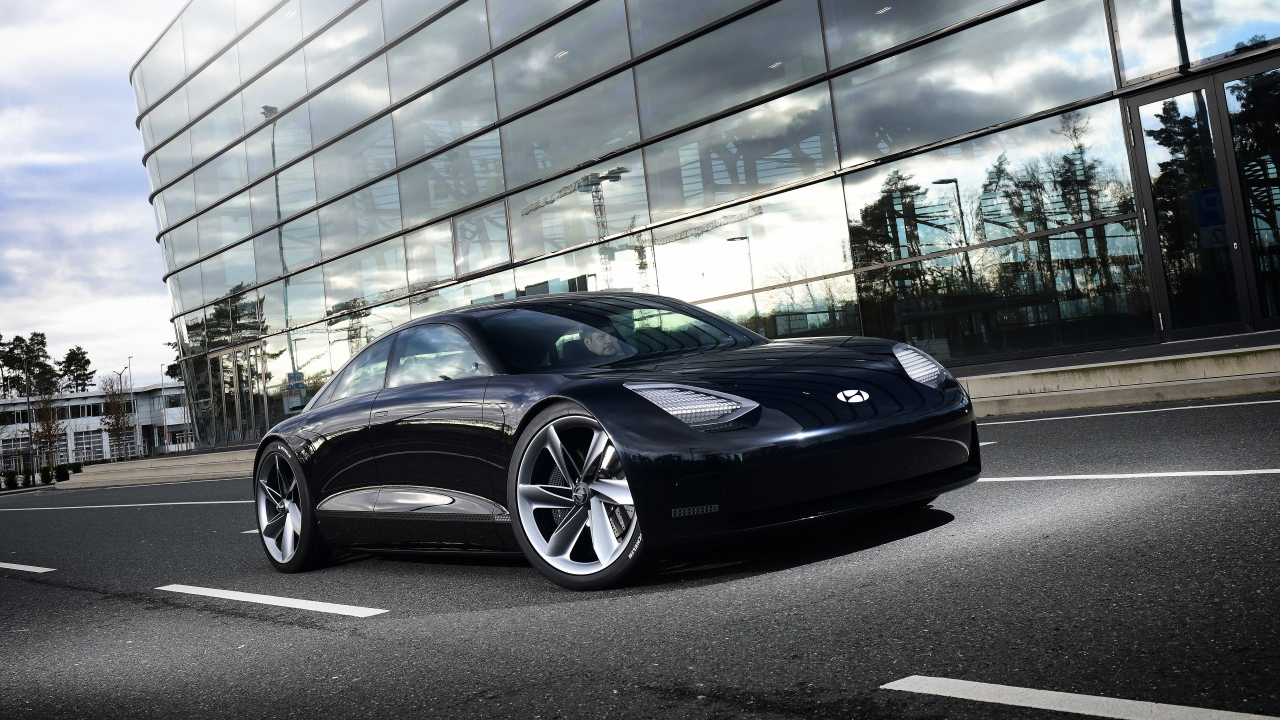 Черный автомобиль Hyundai Prophecy 2020 года у стеклянного здания 