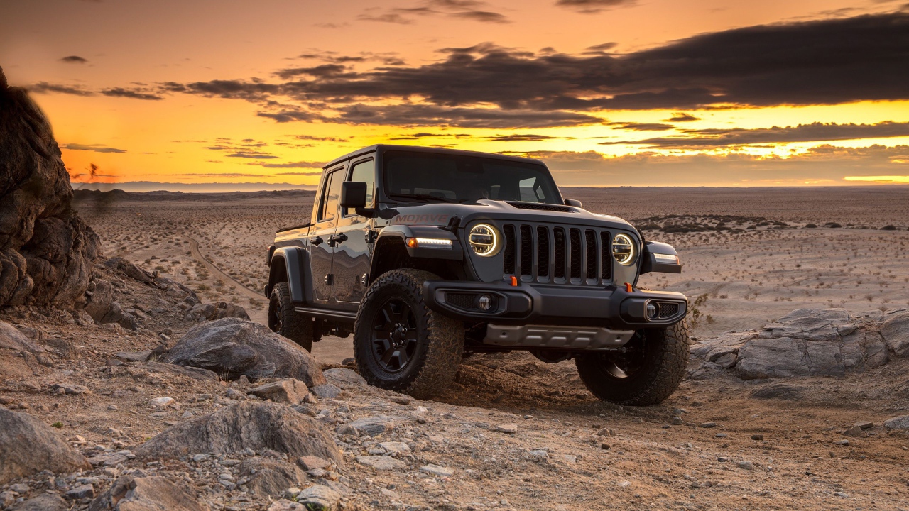 Черный внедорожник Jeep Gladiator Mojave, 2020 года в пустыне на закате