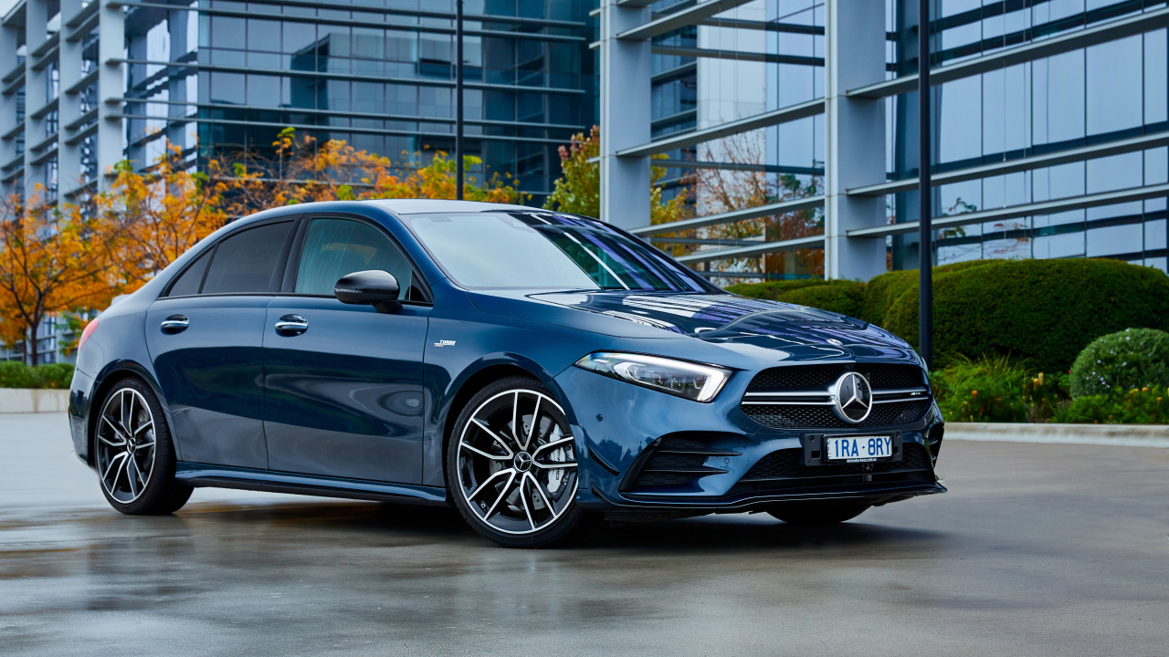 Синий автомобиль Mercedes-Benz AMG A 35, 2020 года на фоне здания 