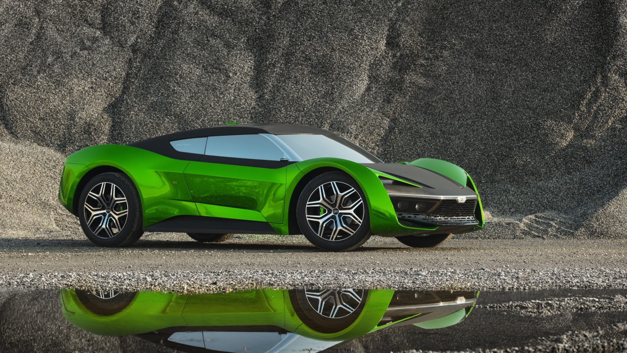 Зеленый автомобиль GFG Vision 2020 года отражается в луже