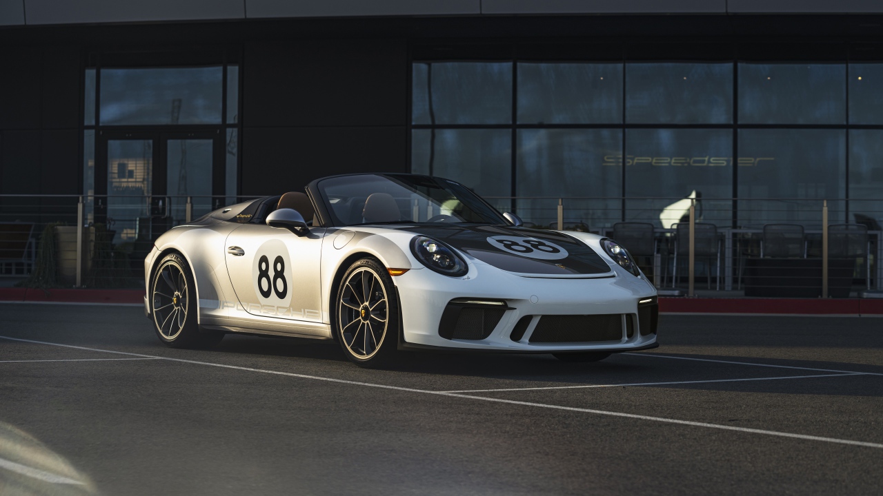 Спортивный автомобиль Porsche 911, 2019 года у стеклянного здания