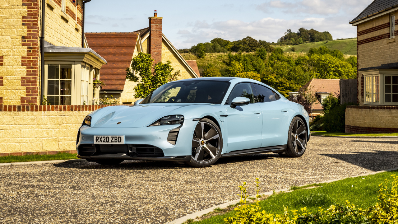 Голубой автомобиль Porsche Taycan 4S 2021 года у дома вид спереди