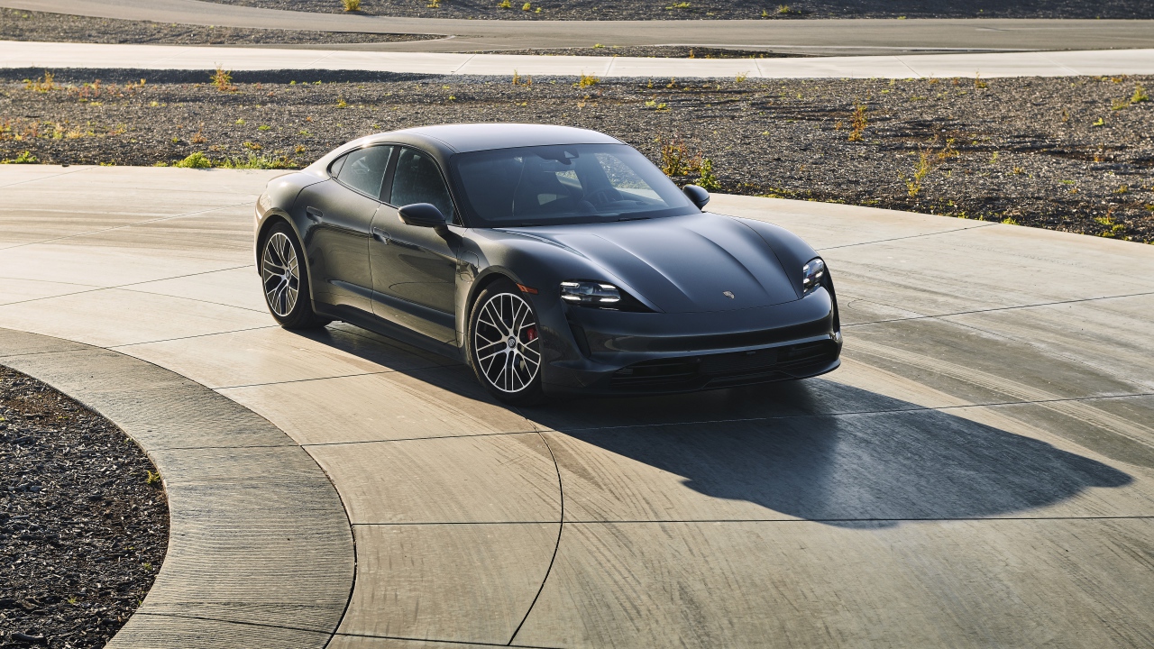 Черный автомобиль Porsche Taycan, 2020 года на дороге 