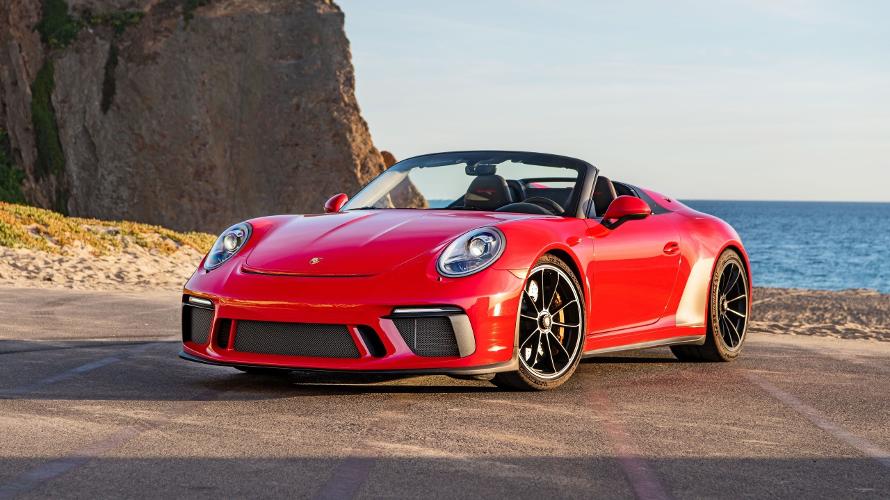 Красный автомобиль Porsche 911 Speedster, 2019 года у воды