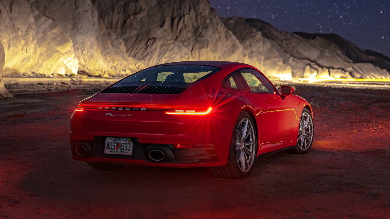 Красный автомобиль  Porsche 911 Carrera S, 2020 года в горах ночью 