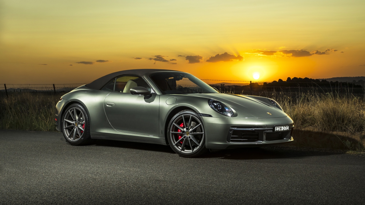 Серебристый Porsche 911 Carrera S Cabriolet 2020 года на закате 