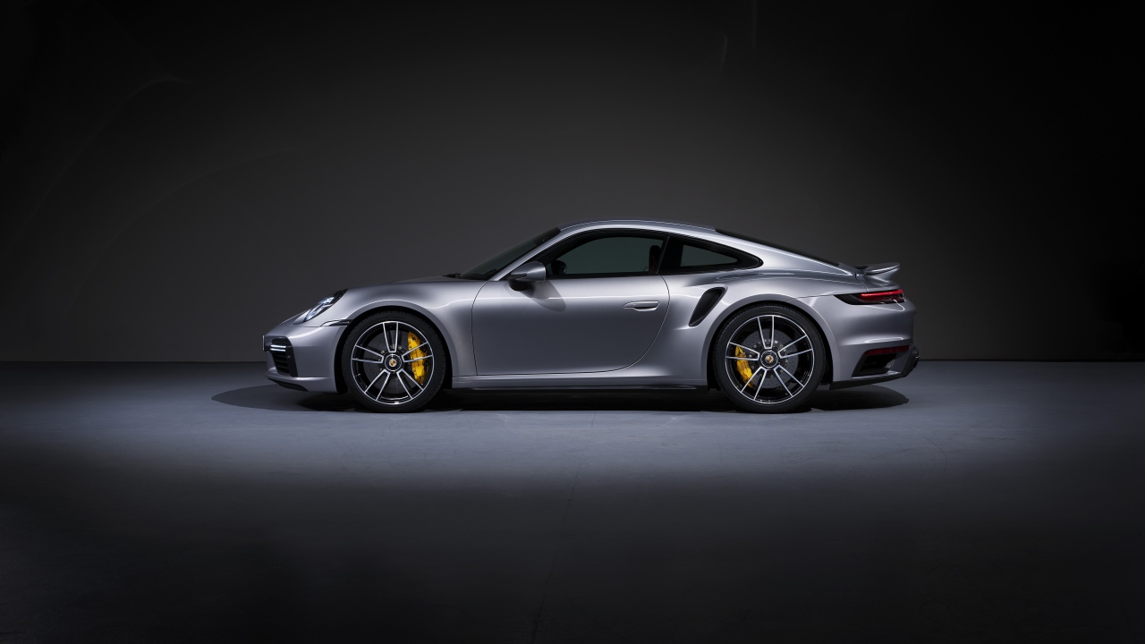 Серебристый автомобиль Porsche 911 Turbo S 2020 года вид сбоку 