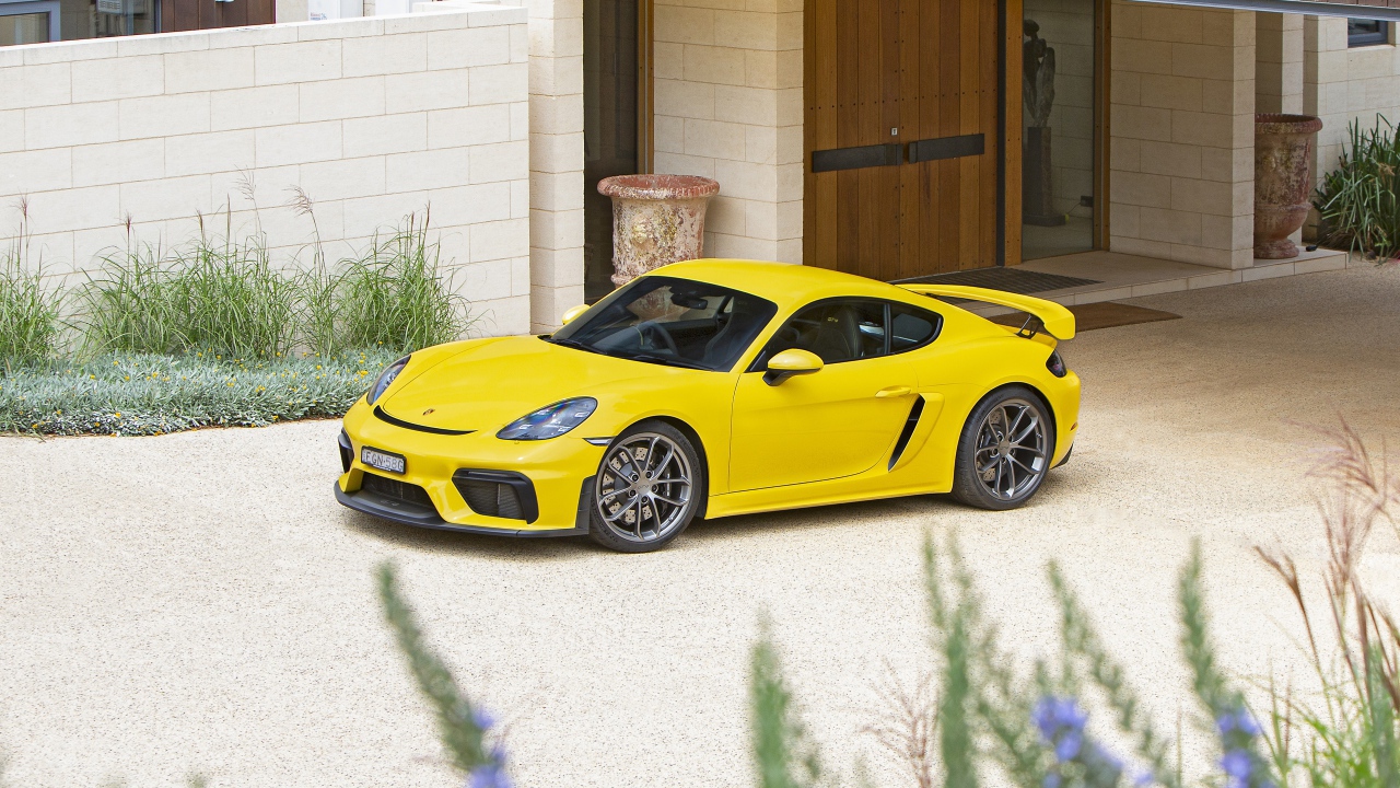 Желтый автомобиль Porsche 718 Cayman GT4,  2020 года