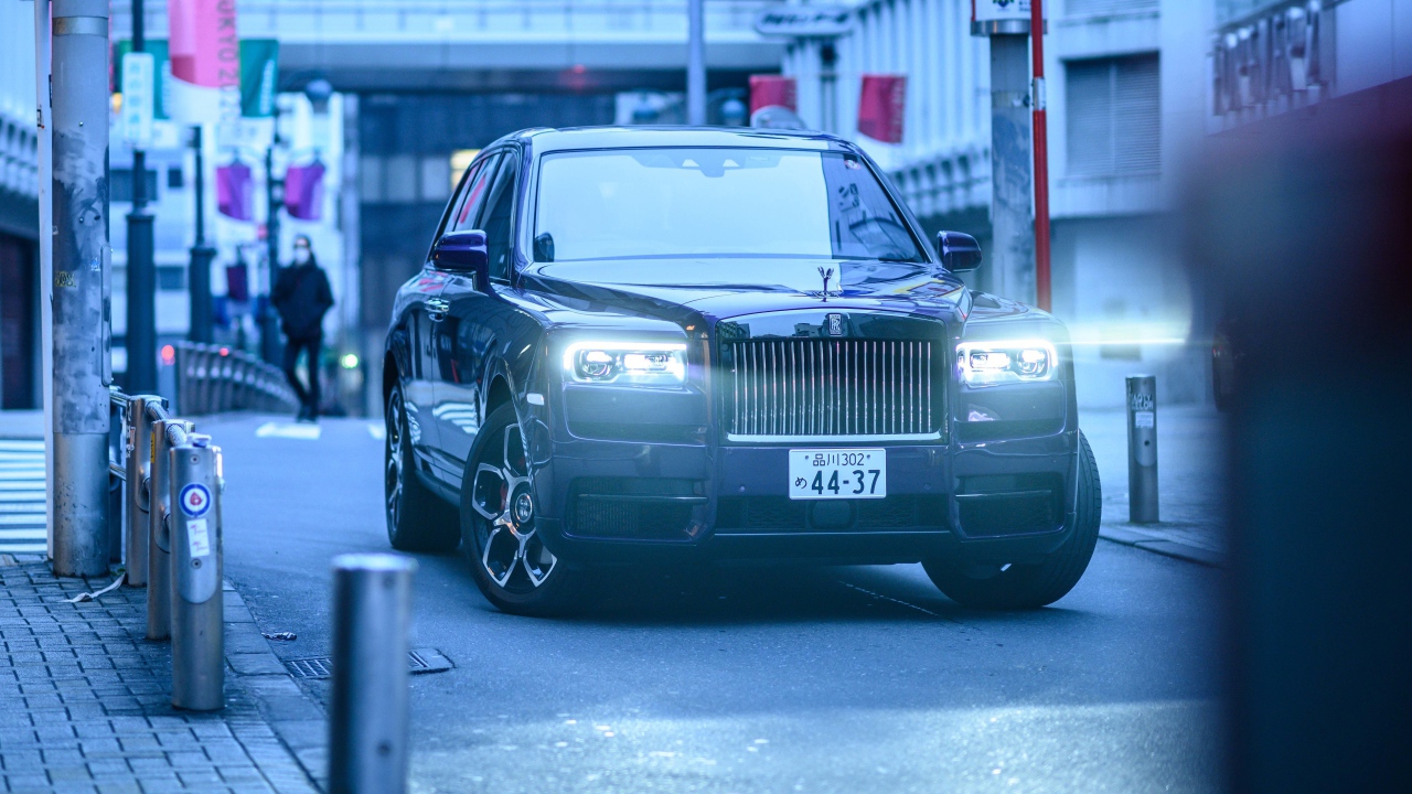 Автомобиль Rolls-Royce Cullinan с включенными фарами