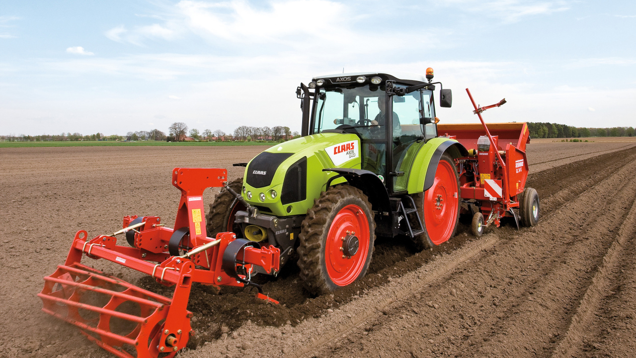 Большой комбайн сеет в поле 