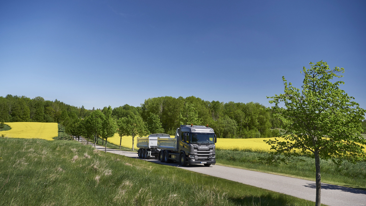 Грузовик Scania Trucks на трассе у поля