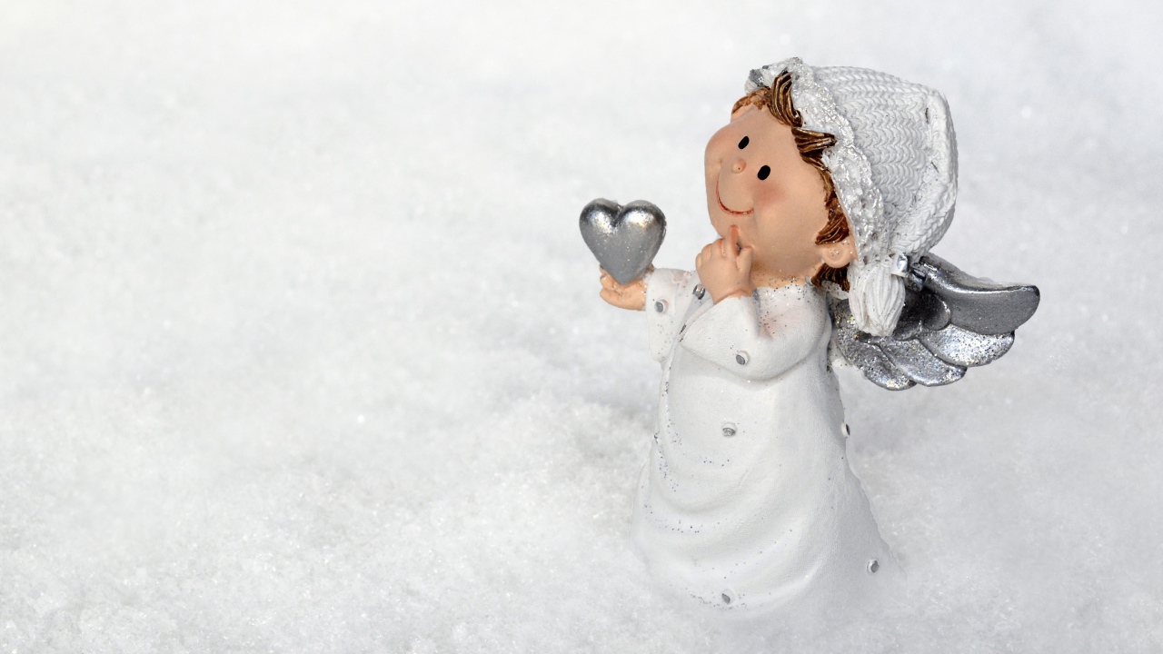 Статуэтка ангела стоит на снегу 