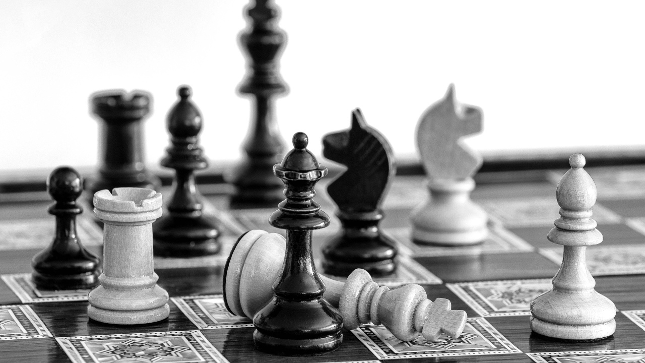 Черные и белые шахматные фигуры на доске 