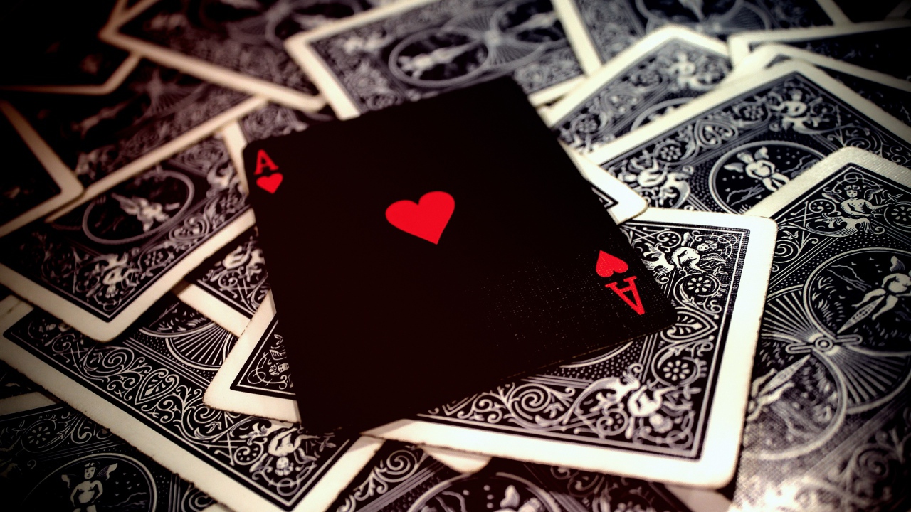 Black card ace of hearts on the table with a deck
