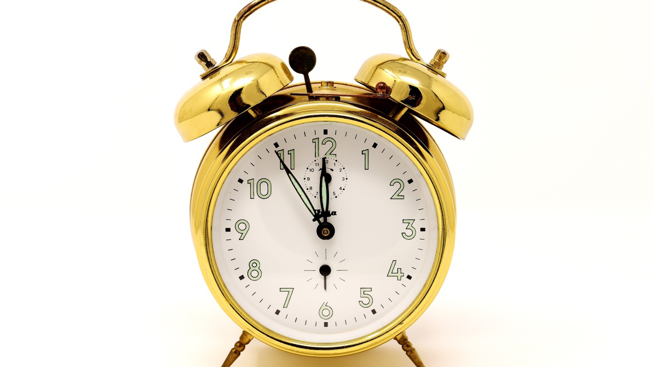 Золотой будильник на белом фоне 