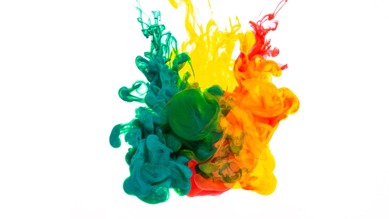 Зеленая и желтая краска растворяются в воде на белом фоне