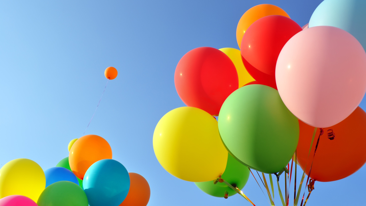 Много разноцветных воздушных шаров на голубом фоне