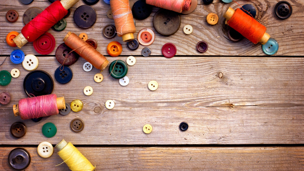 Разноцветные пуговицы и нитки лежат на столе