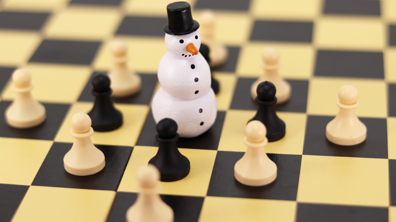 Фигурка снеговика на шахматной доске