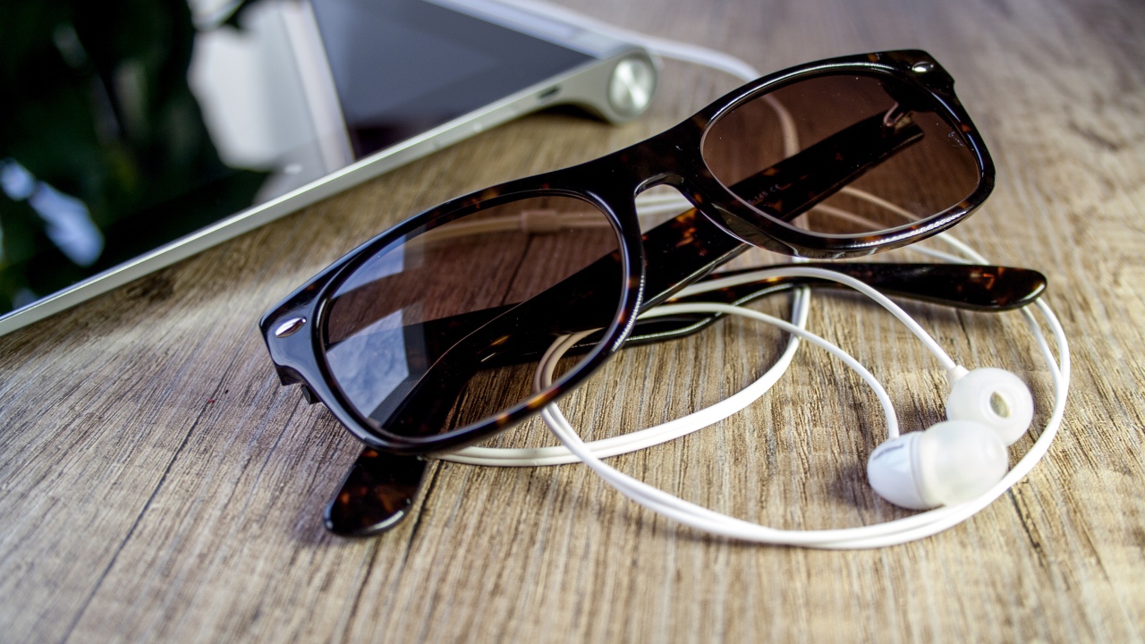 Солнечные очки с наушниками на столе