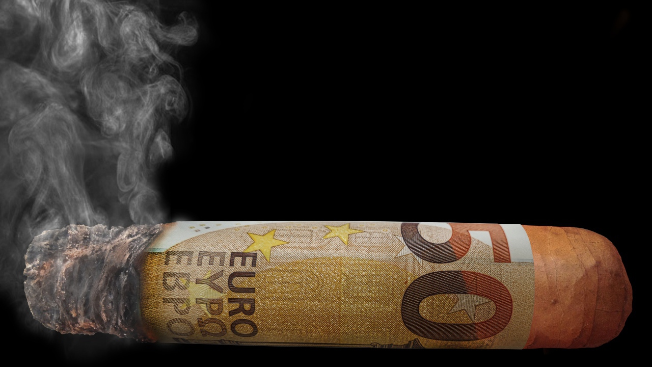 Сигара из купюры евро на черном фоне