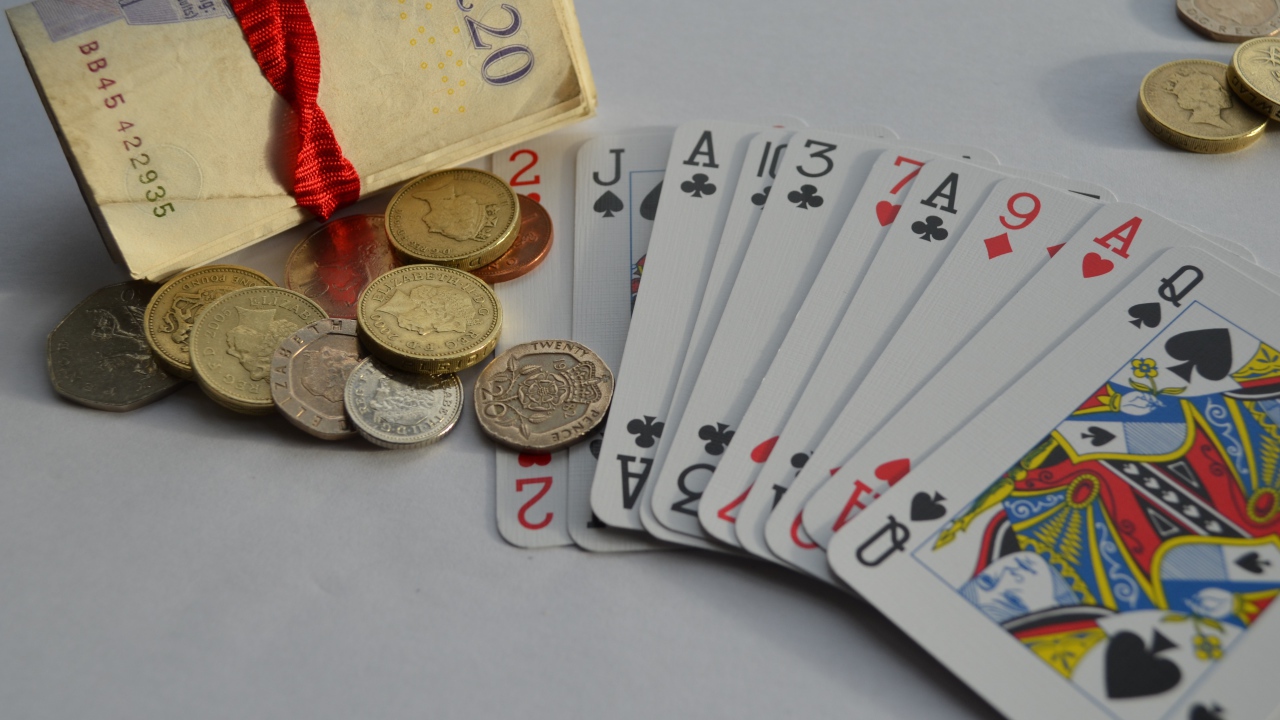 Деньги, монеты и колода карт на столе