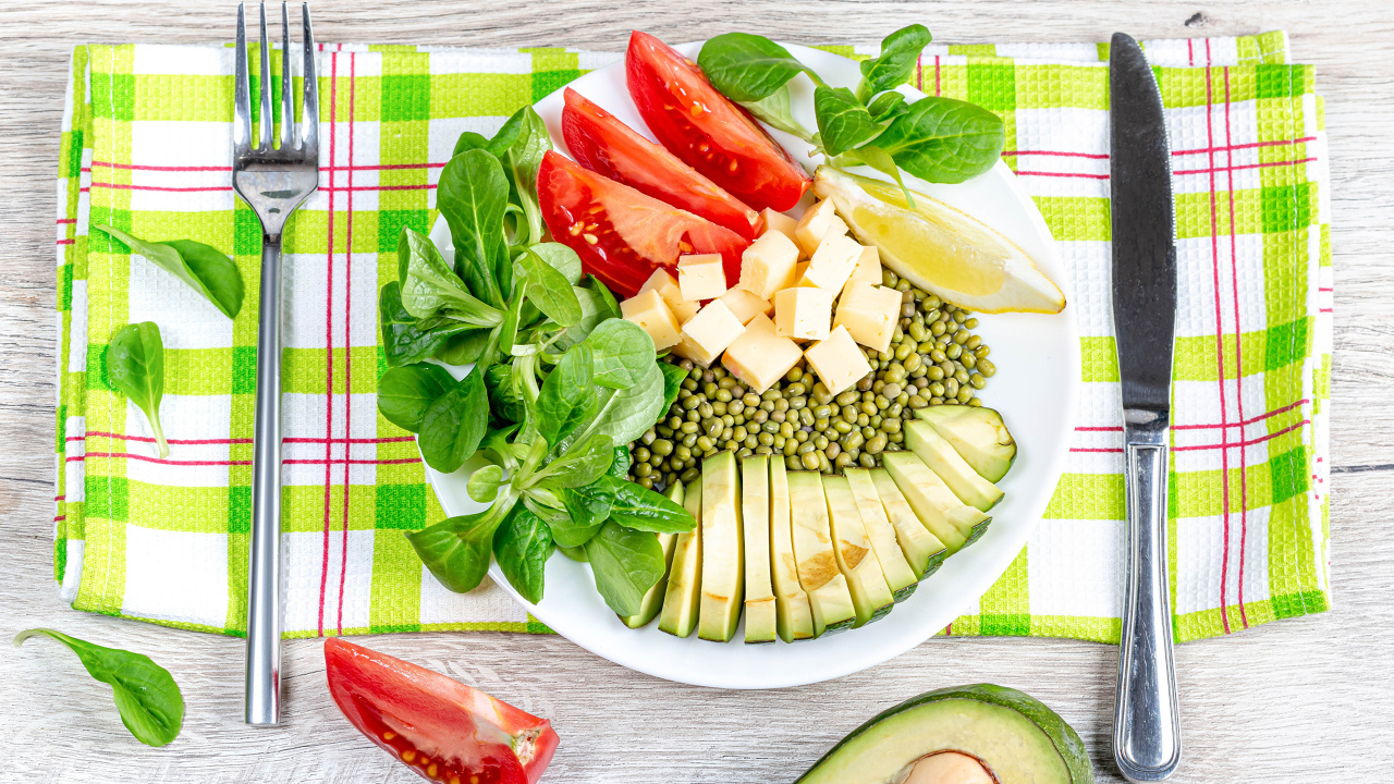 Аппетитные  свежие овощи с сыром и лимоном на тарелке 