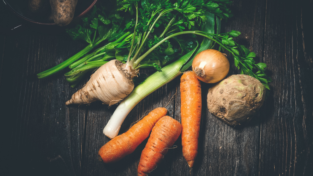 Сельдерей, морковь и лук на столе 