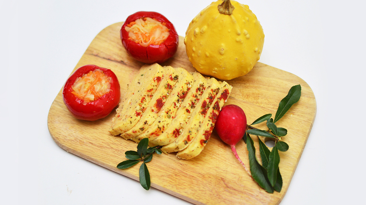 Сыр с овощами на разделочной доске на белом фоне