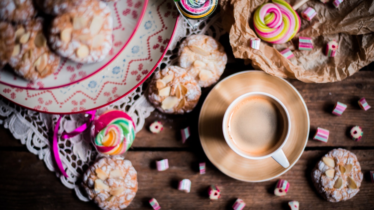Чашка кофе на столе с печеньем и конфетами