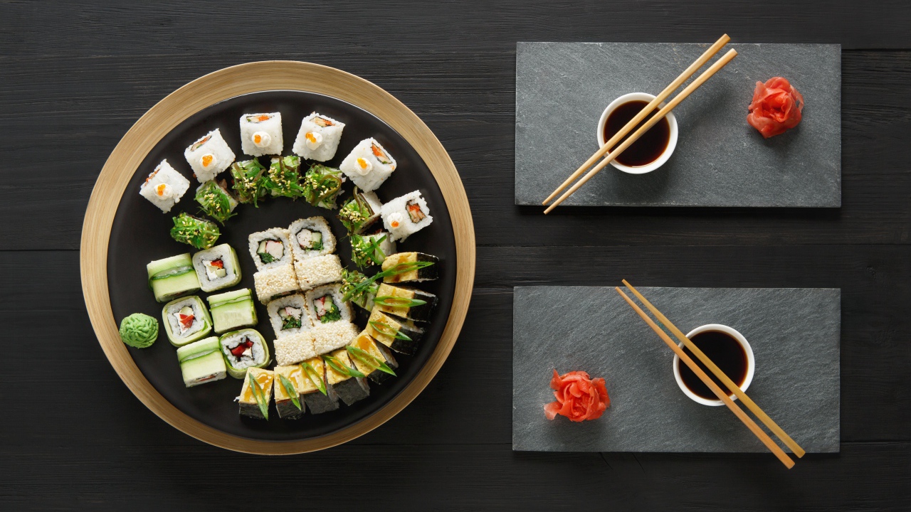 Вкусные  роллы на столе с соевым соусом и палочками 