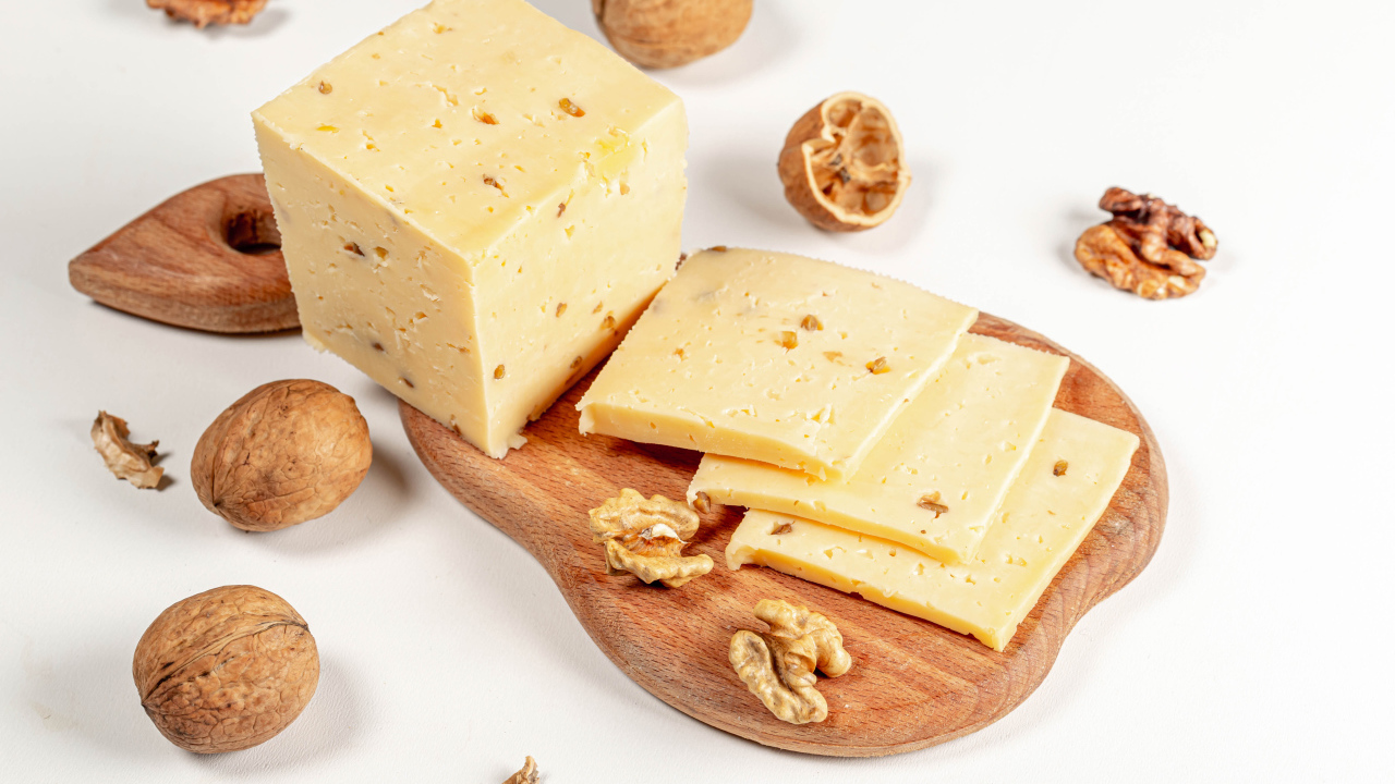 Твердый сыр на доске с грецкими орехами 