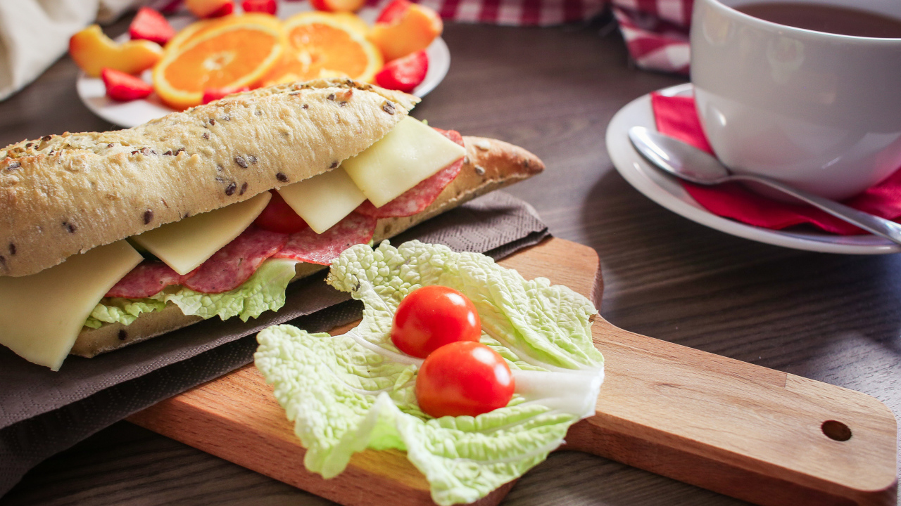 Бутерброды на столе с фруктами и чашкой чая