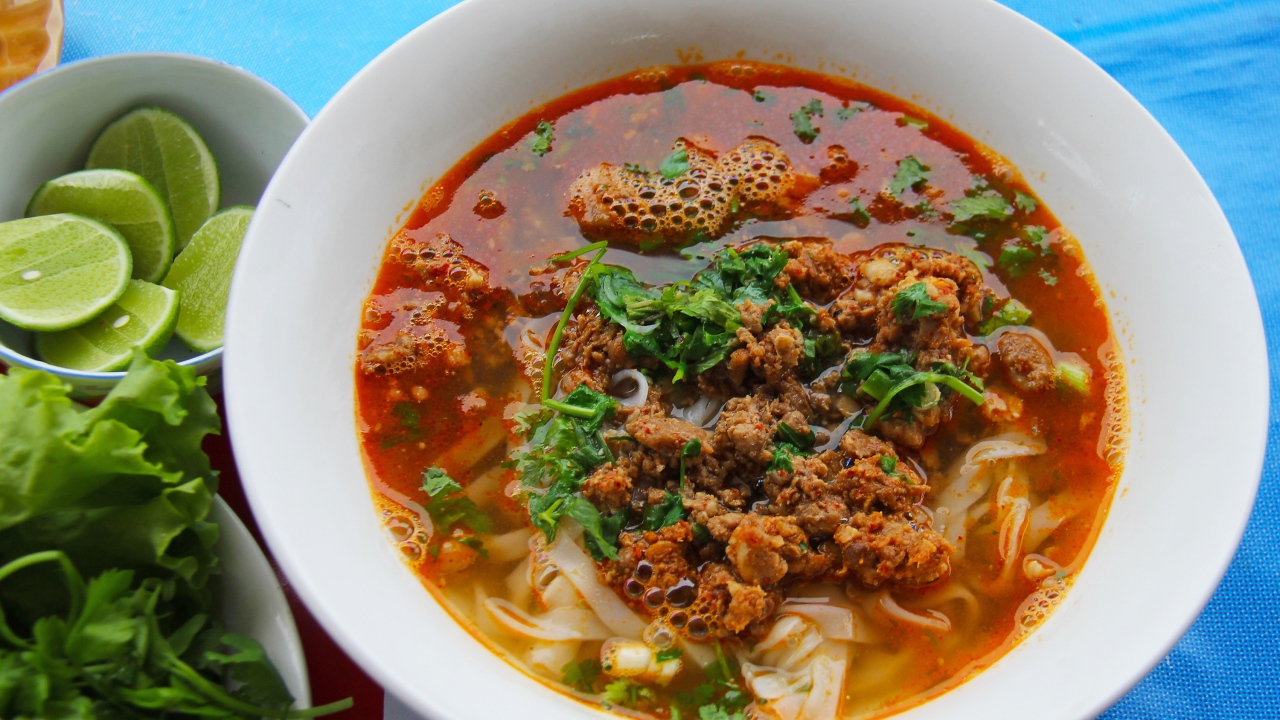 Spicy soup with noodles and meat in a plate with herbs