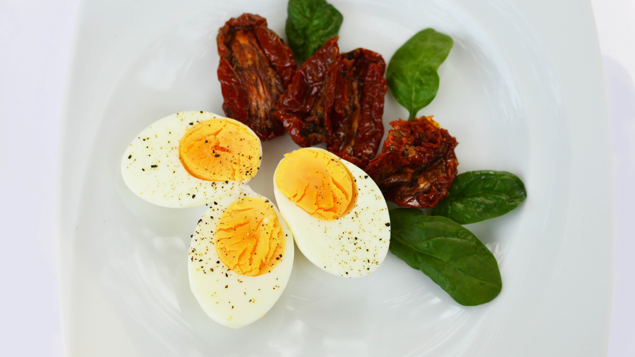 Вяленые помидоры на тарелке с базиликом и вареными яйцами