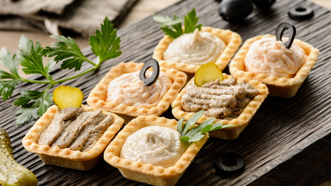 Тарталетки с паштетом на столе с оливками 