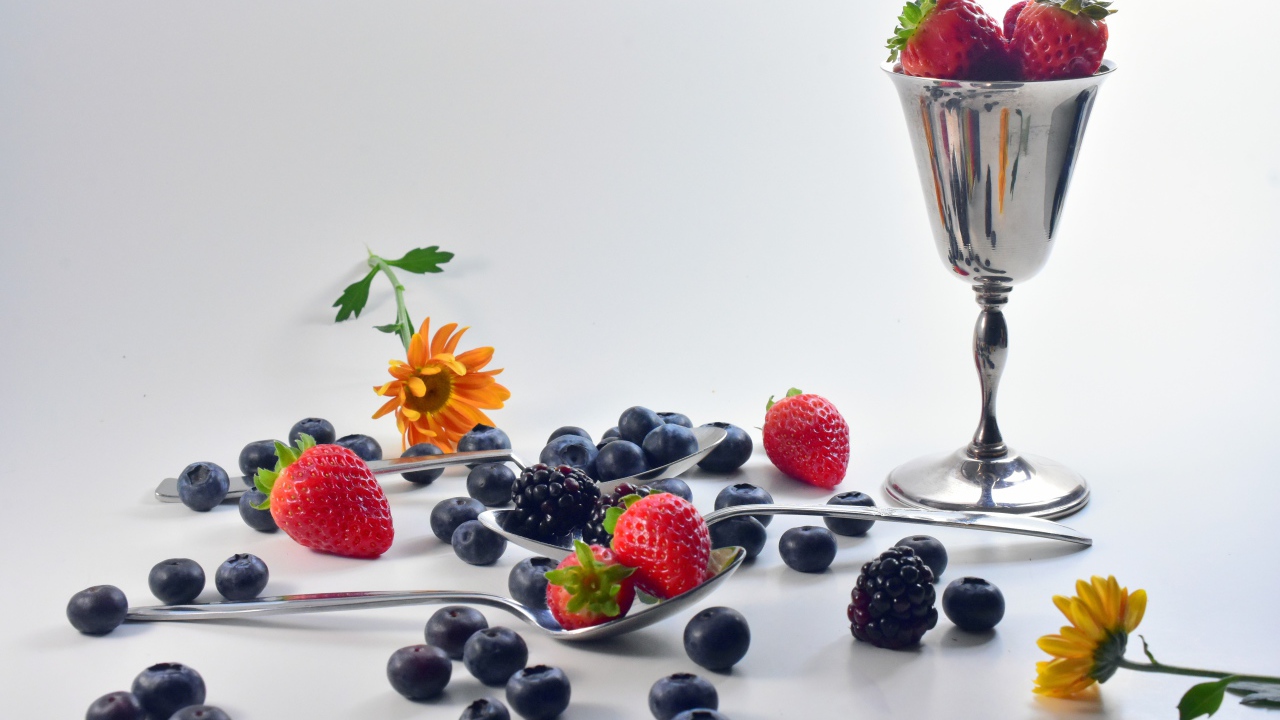 Blackberries, blueberries and strawberries on a table with spoons