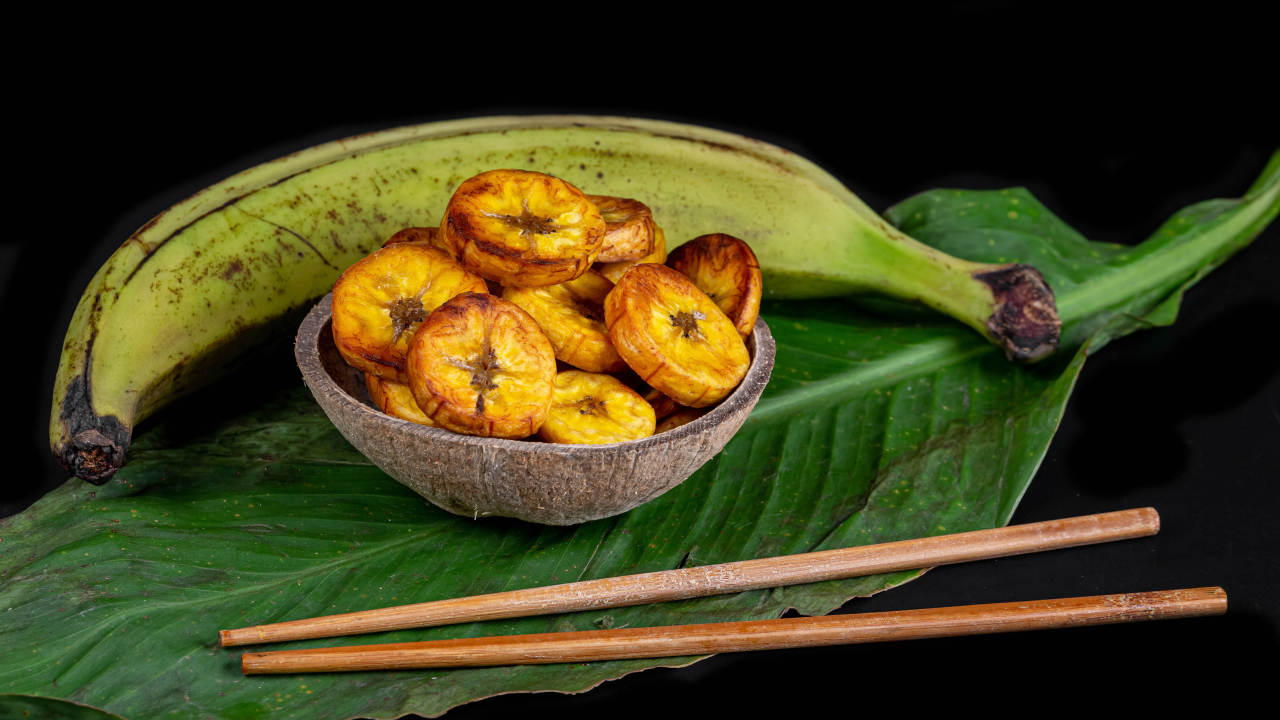Сушеные бананы на столе с палочками и зеленым листом