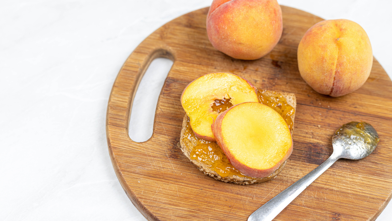 Свежие персики на столе с хлебом 