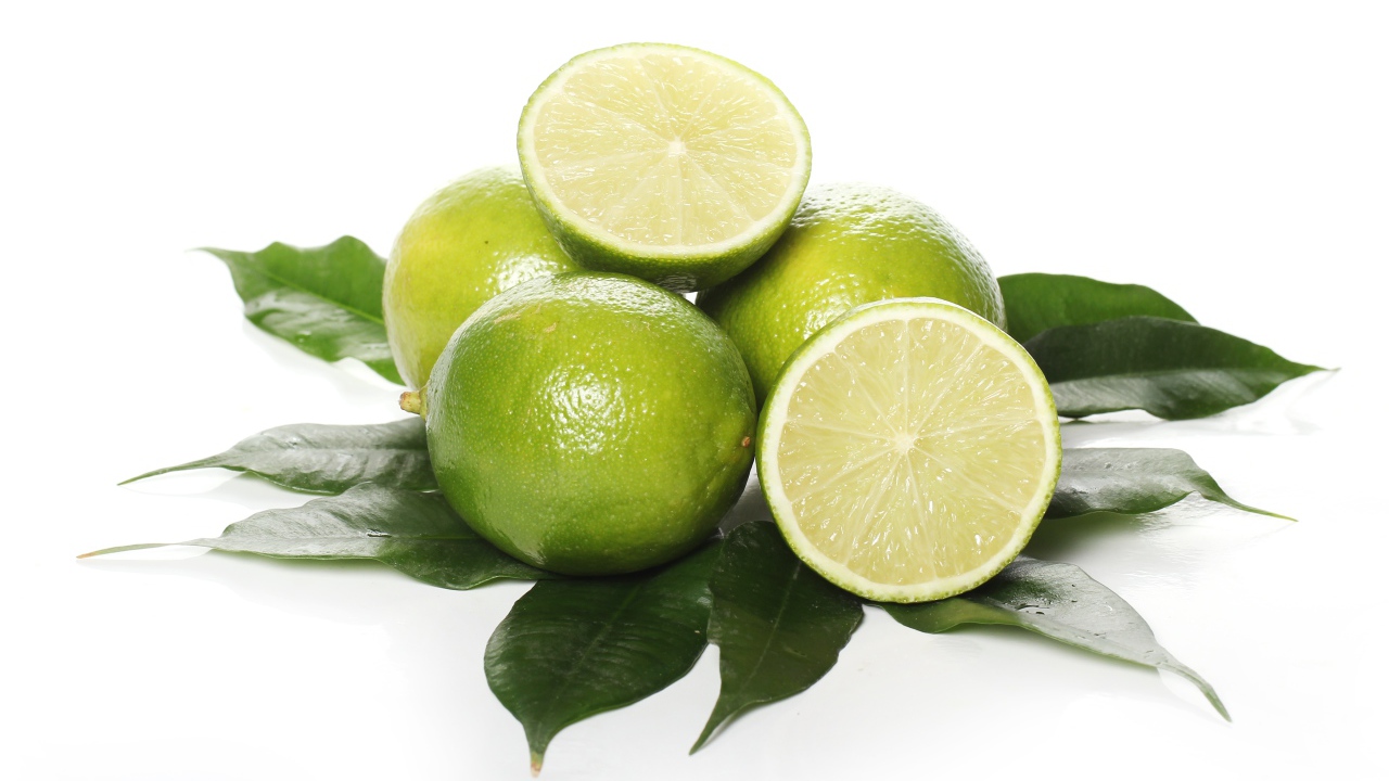 Зеленые лаймы с листьями на белом фоне