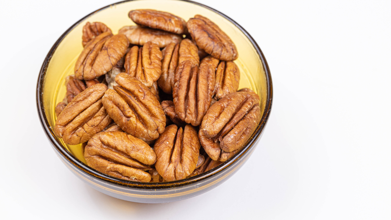 Ядра орехов в миске на белом фоне