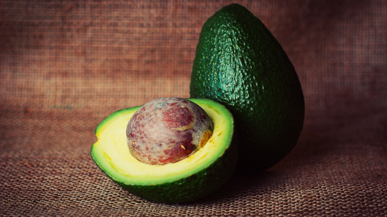Большой зеленый плод авокадо с круглой косточкой