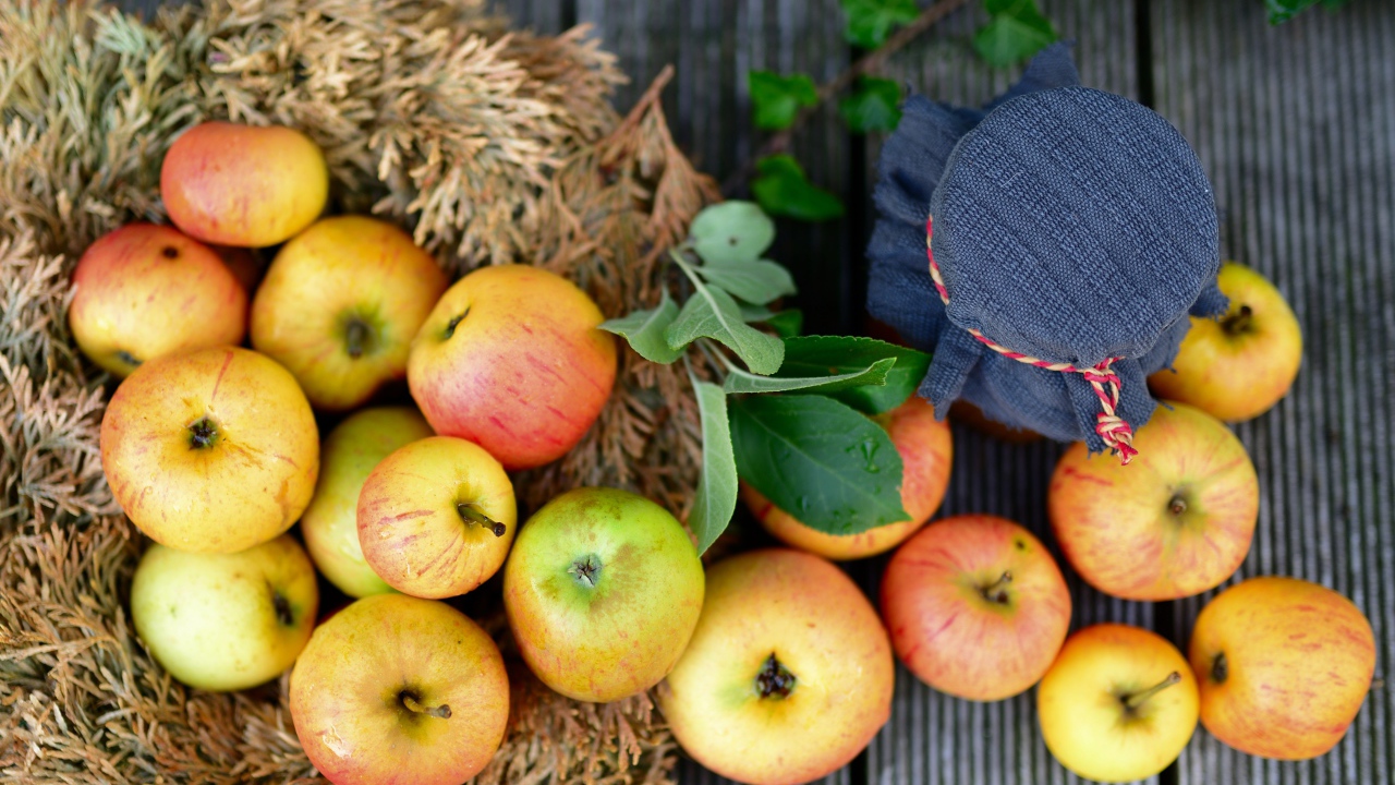 Много спелых яблок на столе с вареньем 