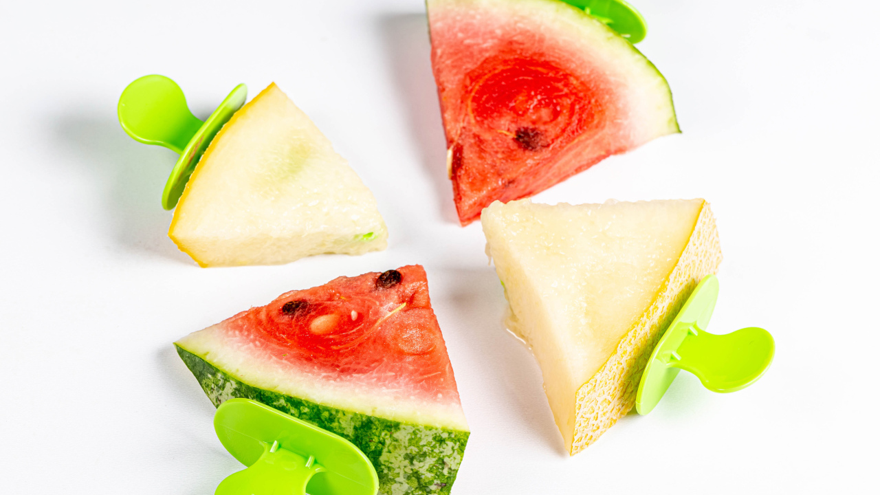 Кусочки арбуза и дыни на палочках на белом фоне