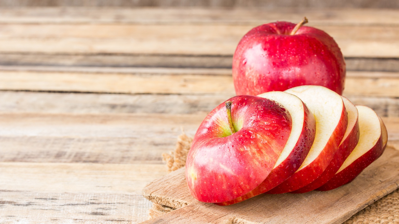 Нарезанное яблоко на разделочной доске 