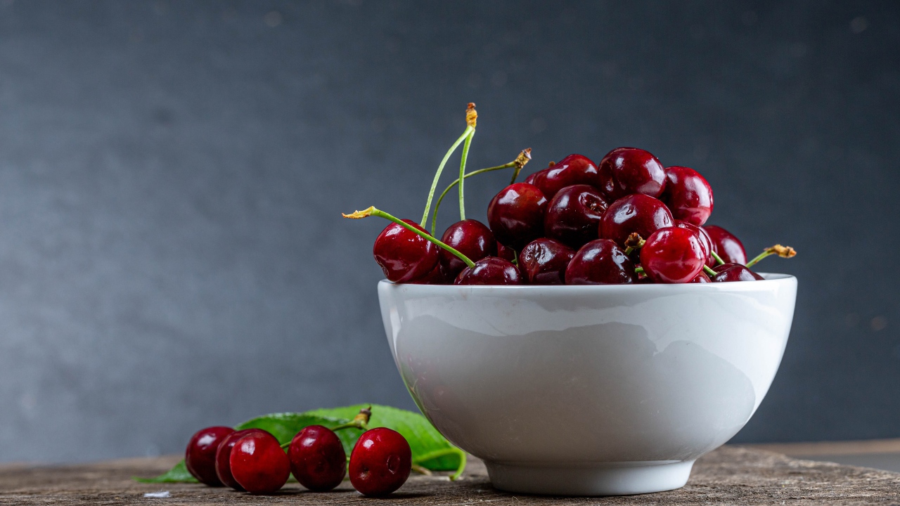 Белая фарфоровая тарелка с красной спелой черешней 