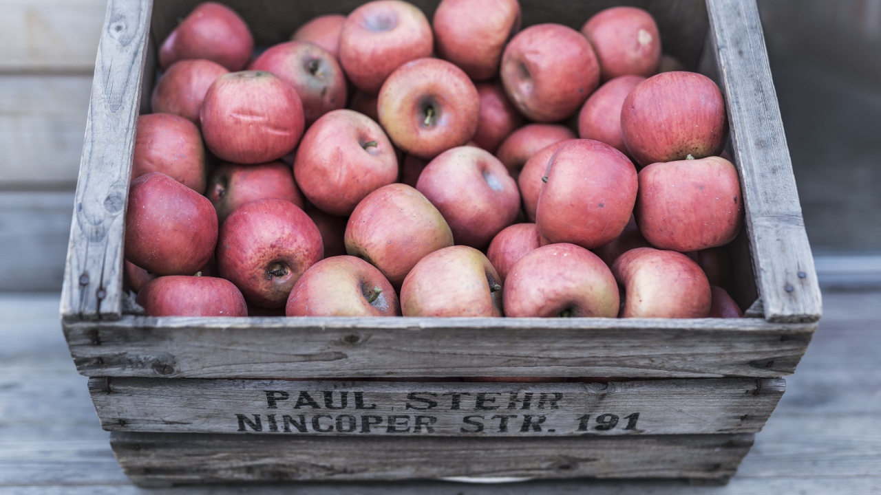 Деревянный ящик с красными спелыми яблоками