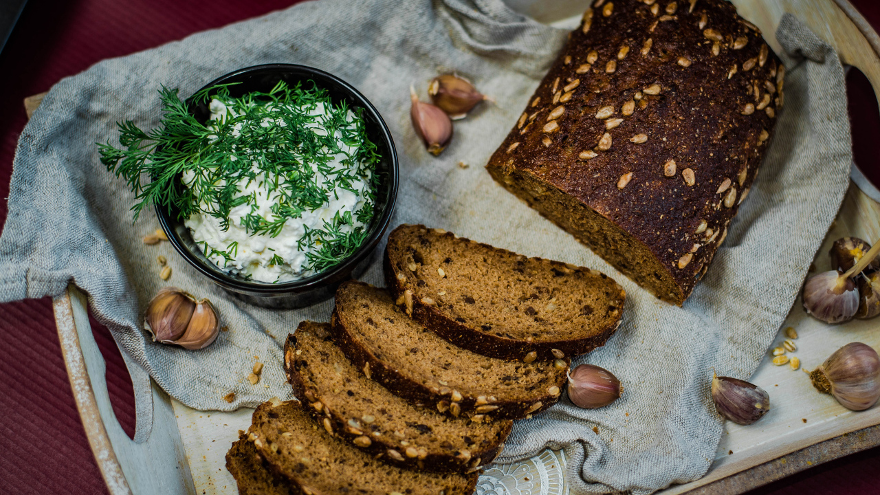 Свежий хлеб с зернами на столе с соусом и чесноком