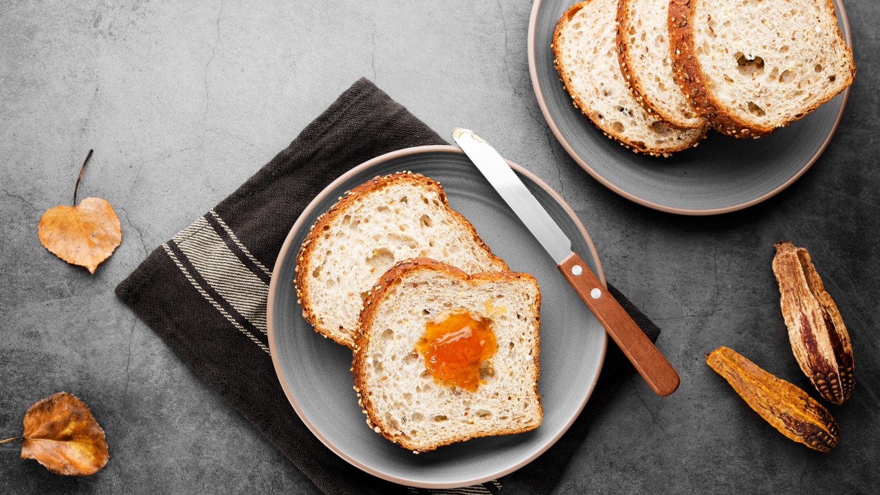 Куски хлеба с джемом на сером столе 