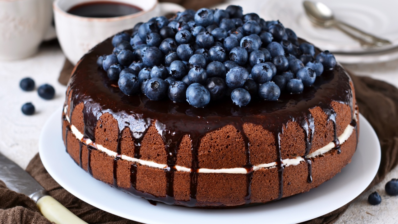 Шоколадный пирог с ягодами черники  на столе с кофе